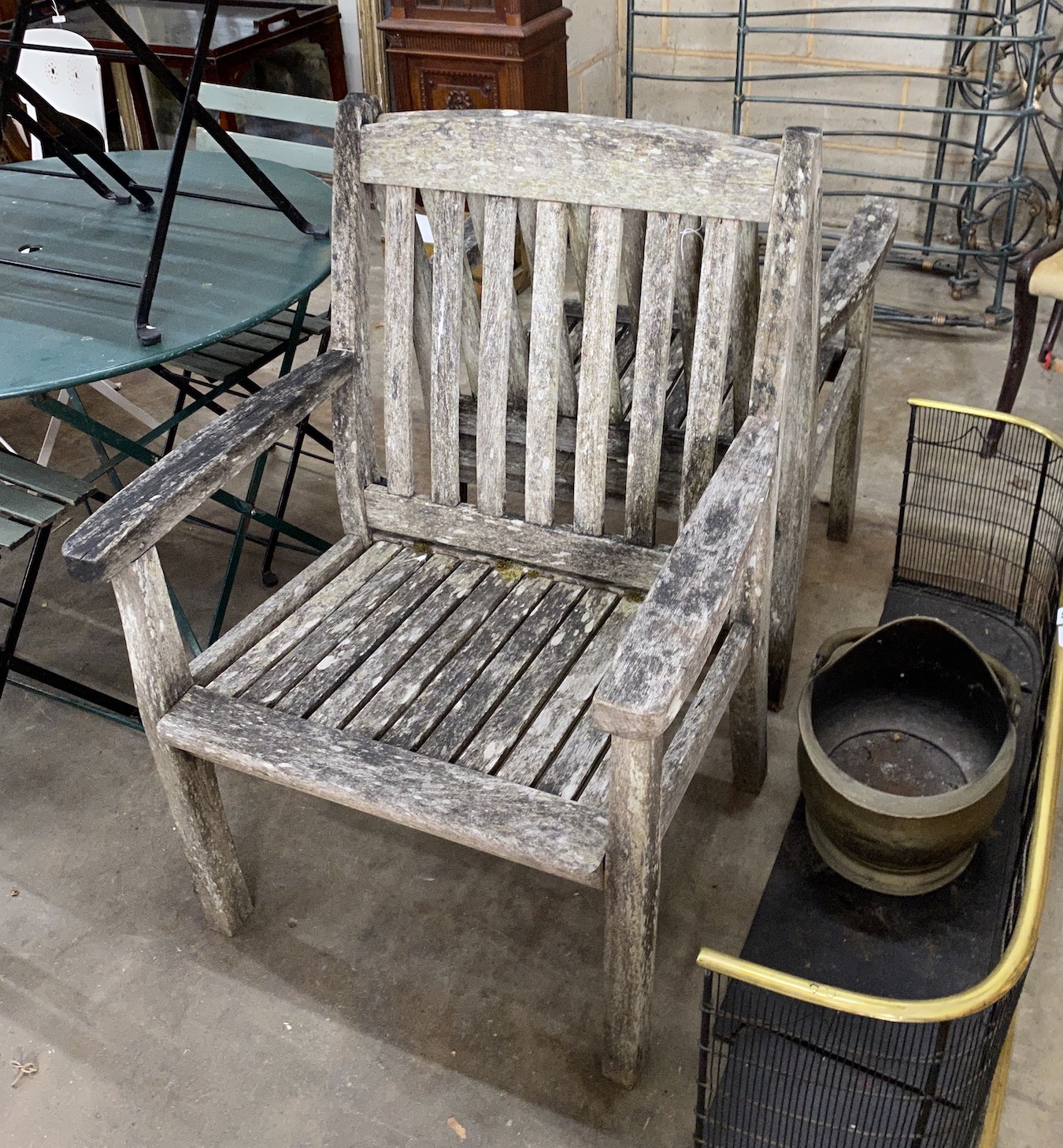 A pair of weathered teak garden elbow chairs, width 68cm, depth 52cm, height 95cm